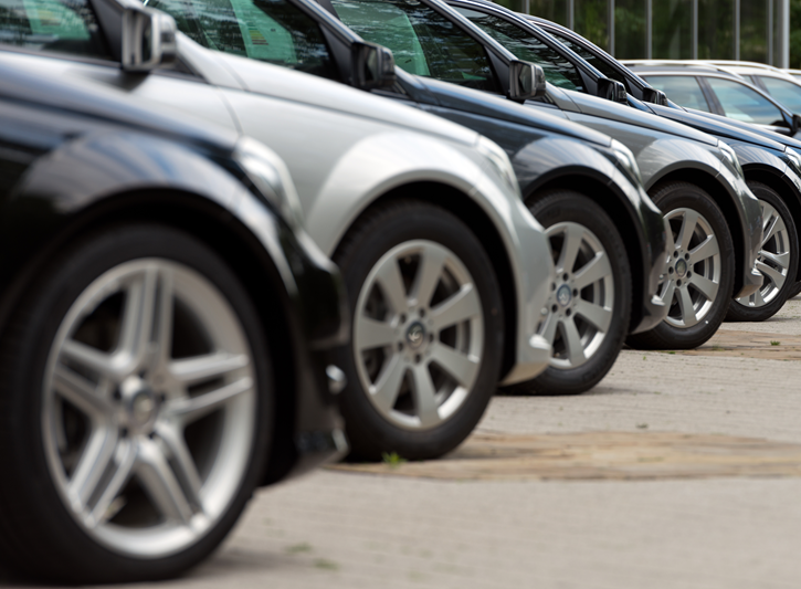 Row of black, silver and grey cars on dealer forecourt