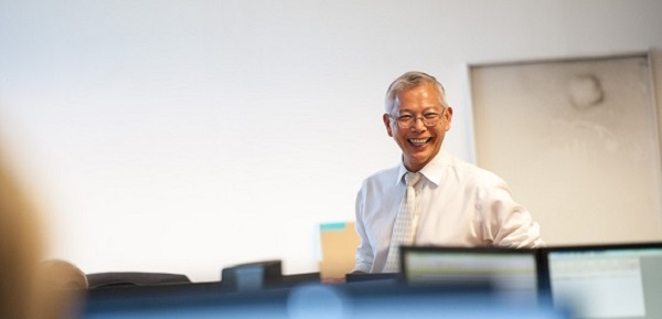 Man standing in office laughing